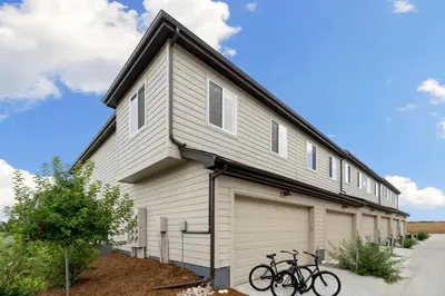 a house with a garage with two bikes parked outside at Mosaic Modern - Dog Friendly, Pool and King Suite in Fort Collins