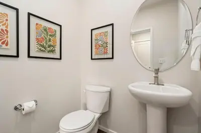 a bathroom with a white toilet and a mirror at Mosaic Modern - Dog Friendly, Pool and King Suite in Fort Collins