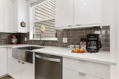 a kitchen with white cabinets and a counter with a sink at Elegant Mountain Haven - King Bed and Fireplaces in Fort Collins