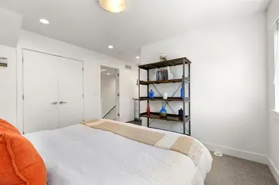 a white bedroom with a bed and a book shelf at Elegant Mountain Haven - King Bed and Fireplaces in Fort Collins
