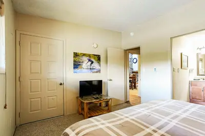 a bedroom with a bed and a flat screen tv at Whisk Away to Winter Park 2 BDR 5 Min from Skiing in Winter Park