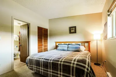 a bedroom with a bed and a bathroom at Whisk Away to Winter Park 2 BDR 5 Min from Skiing in Winter Park