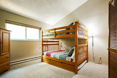 a bedroom with two bunk beds and a window at Whisk Away to Winter Park 2 BDR 5 Min from Skiing in Winter Park