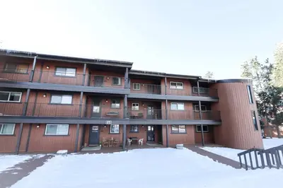 an apartment building with snow in front of it at Whisk Away to Winter Park 2 BDR 5 Min from Skiing in Winter Park