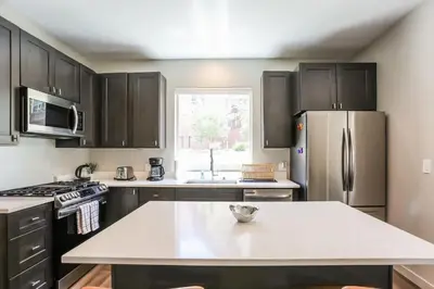 a kitchen with black cabinets and a stainless steel refrigerator at Granby Colorful Adventures - Breathtaking Views in Granby