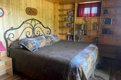 a bedroom with a bed in a room with book shelves at Cabin Rental for Large Groups Ideal for Colorado Glamping in Walden