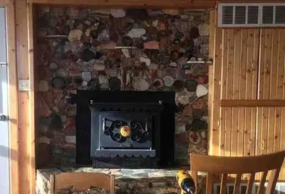 a fireplace in a room with a stone wall at Cabin Rental for Large Groups Ideal for Colorado Glamping in Walden
