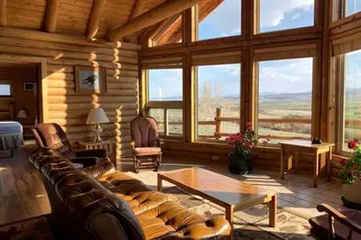 a living room with a couch and some windows at Cabin Rental for Large Groups Ideal for Colorado Glamping in Walden
