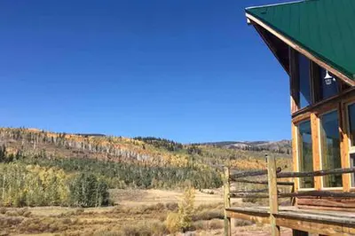 a building with a green roof with a view of a mountain at Cabin Rental for Large Groups Ideal for Colorado Glamping in Walden