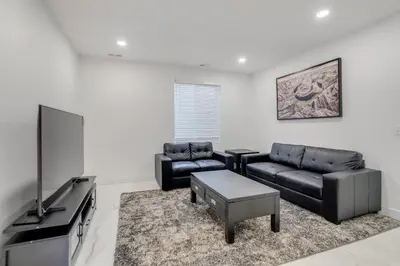 a living room with black furniture and a flat screen tv at 16 Mi to Dtwn Denver Modern Apt with Patio in Denver