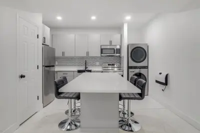 a kitchen with a white table and black chairs at 16 Mi to Dtwn Denver Modern Apt with Patio in Denver