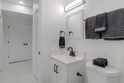 a white bathroom with a sink and a mirror at 16 Mi to Dtwn Denver Modern Apt with Patio in Denver