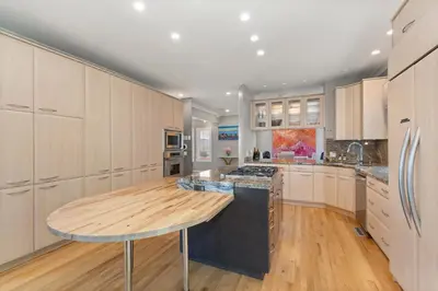 a large kitchen with a wooden island in the middle at Heart of Cherry Creek Group Retreat Hot Tub in Denver