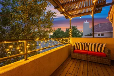 a patio with a bench and lights on a fence at Heart of Cherry Creek Group Retreat Hot Tub in Denver