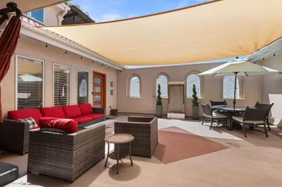 a patio with a red couch and a table and chairs at Heart of Cherry Creek Group Retreat Hot Tub in Denver