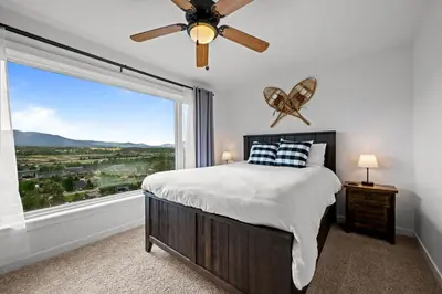 a bedroom with a bed and a large window at 838B Wapiti Dr in Fraser