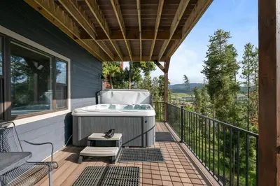 a deck with a bath tub and a table and chairs at 838B Wapiti Dr in Fraser