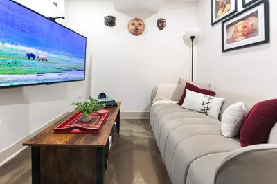 a living room with a couch and a flat screen tv at Chic Lower-Level Stay - Prime Walkable Locale in Denver
