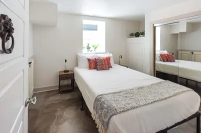 a small bedroom with two beds and a window at Chic Lower-Level Stay - Prime Walkable Locale in Denver