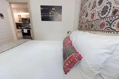 a white bed with a pillow on top of it at Chic Lower-Level Stay - Prime Walkable Locale in Denver