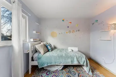 a childs bedroom with a bed and a window at Spacious and Comfy Close to Everything Backyard in Longmont