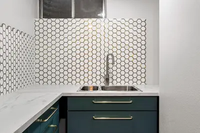 a kitchen with a sink and a tile wall at Spacious and Comfy Close to Everything Backyard in Longmont