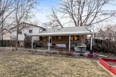 a white house with a porch and a yard at Spacious and Comfy Close to Everything Backyard in Longmont