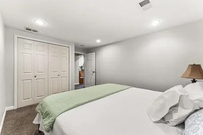 a bedroom with a large white bed with a lamp at Modern Downtown Oasis Sunny Garden King Beds in Longmont