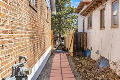 a house with a hose attached to a brick wall at Modern Downtown Oasis Sunny Garden King Beds in Longmont