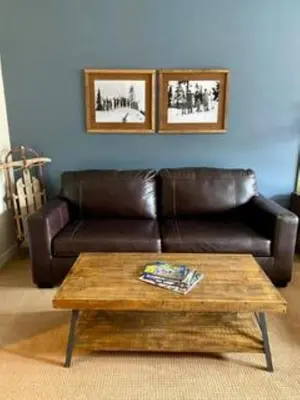 a living room with a leather couch and a coffee table at Fraser Crossing Top floor 3603 in Winter Park