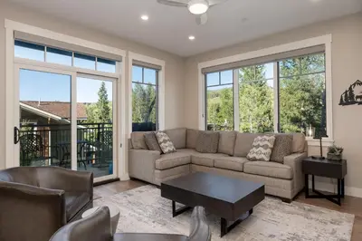a living room with a couch and chairs and windows at Downtown Flat condo in Winter Park