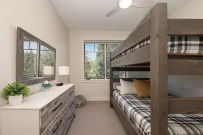 a bedroom with a bunk bed and two windows at Downtown Flat condo in Winter Park