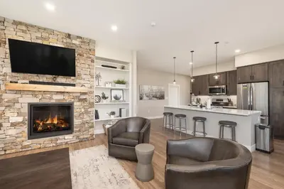 a living room with a fireplace and a bar with chairs at Downtown Flat condo in Winter Park