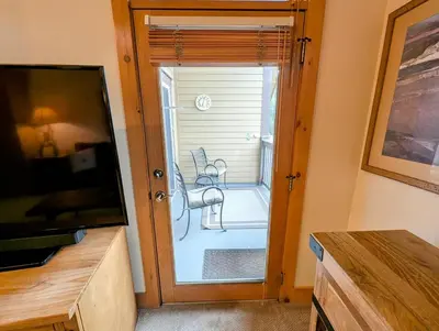 a room with a sliding glass door with a chair outside at Expedition Station 8634 by SummitCove Lodging in Keystone