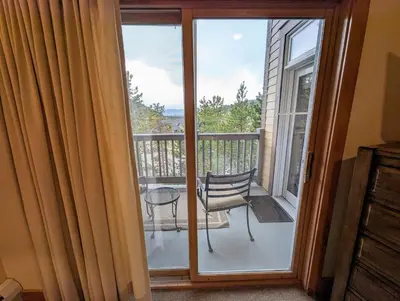 a sliding glass door to a balcony with a chair at Expedition Station 8634 by SummitCove Lodging in Keystone