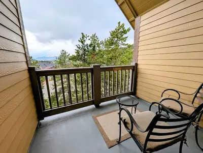a porch with two chairs and a balcony with a view at Expedition Station 8634 by SummitCove Lodging in Keystone