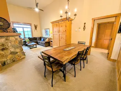 a living room with a wooden table and chairs at Expedition Station 8634 by SummitCove Lodging in Keystone