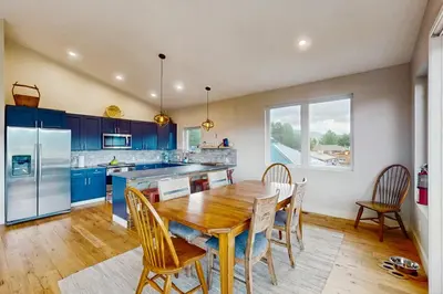 a kitchen with blue cabinets and a wooden table and chairs at Lance's Adventure Lodge in Tabernash