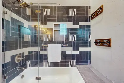 a bathroom with a tub and a glass shower at Lance's Adventure Lodge in Tabernash