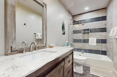 a bathroom with a sink and a toilet and a tub at Lance's Adventure Lodge in Tabernash