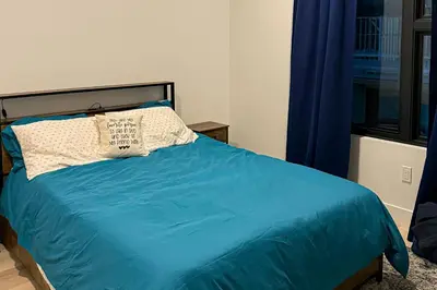 a bed with a blue comforter and a pillow at Modern Mountain Nest in Silverthorne
