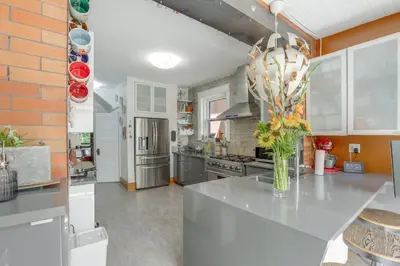 a kitchen with a counter with a vase of flowers on it at Walk to Denver Zoo City Park Getaway with Garden in Denver