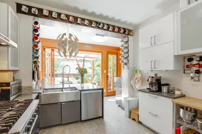 a kitchen with white cabinets and a sink at Walk to Denver Zoo City Park Getaway with Garden in Denver