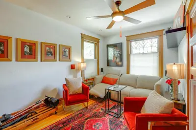 a living room with a couch and red chairs at Walk to Denver Zoo City Park Getaway with Garden in Denver