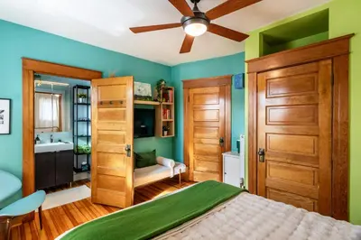 a bedroom with green walls and a ceiling fan at Walk to Denver Zoo City Park Getaway with Garden in Denver
