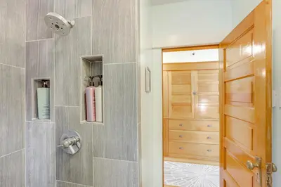 a bathroom with a walk in shower next to a door at Walk to Denver Zoo City Park Getaway with Garden in Denver