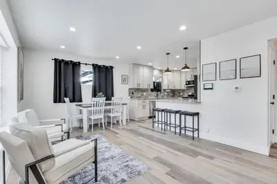 a kitchen and living room with white walls and a table and chairs at Cozy King suite- play room- hot tub in Denver