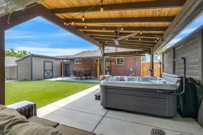 a patio with a hot tub under a pergola at Cozy King suite- play room- hot tub in Denver