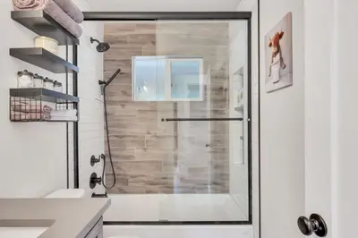 a shower with a glass door in a bathroom at Cozy King suite- play room- hot tub in Denver