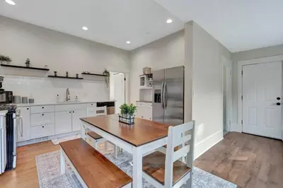 a kitchen with a wooden table and a refrigerator at Longmont 2BD Comfort | Outdoor dining + Parking in Longmont